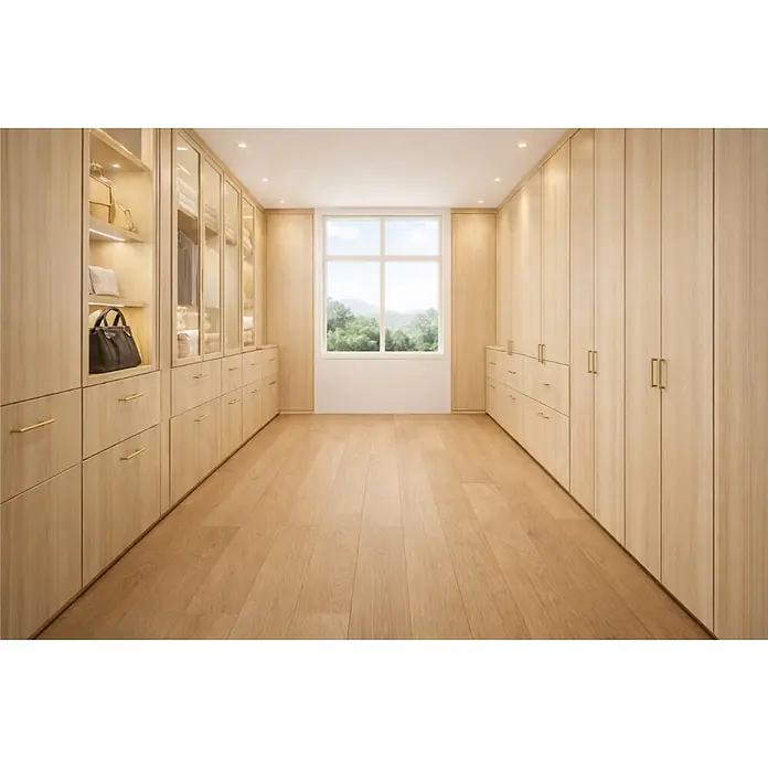 Parkett - Eiche Gobi, 2.200 x 260 x 15 mm - Heller begehbarer Kleiderschrank aus hellem Holz mit goldenen Griffen, offenen Regalen, Glastüren und Schubladen um ein Fenster.