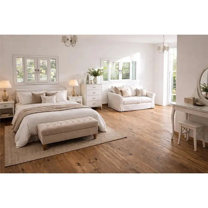 Parkett - Eiche Bernau, Landhausdiele, 1.900 x 190 x 14 mm - Ein helles, elegantes Schlafzimmer mit großem Bett, gepolsterter Bank, Sofa und Schminktisch in Weiß- und Naturtönen auf Holzboden.