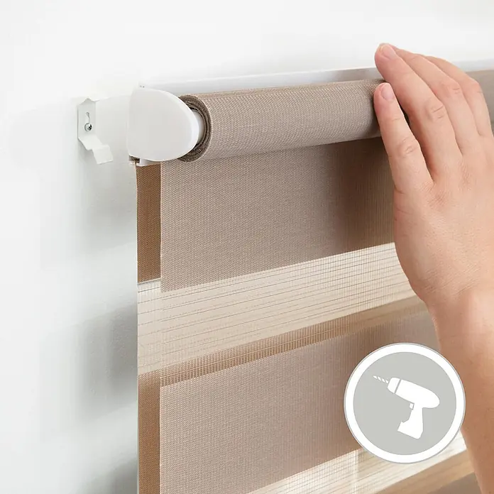 Lichtblick Doppelrollo -  - Hand installiert beiges Duo-Rollos mit wechselnden transparenten und blickdichten Streifen an weißer Wandhalterung. Bohrer-Symbol.
