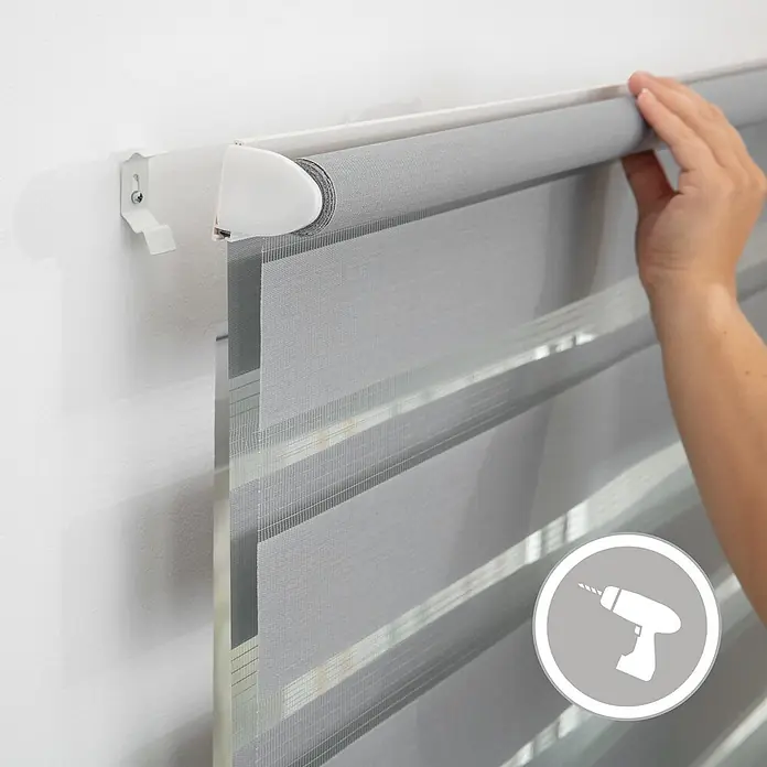 Lichtblick Doppelrollo -  - Graues Duo-Rollo wird an weißen Wandhalterungen installiert, zeigt abwechselnd transparente und blickdichte Stoffstreifen.