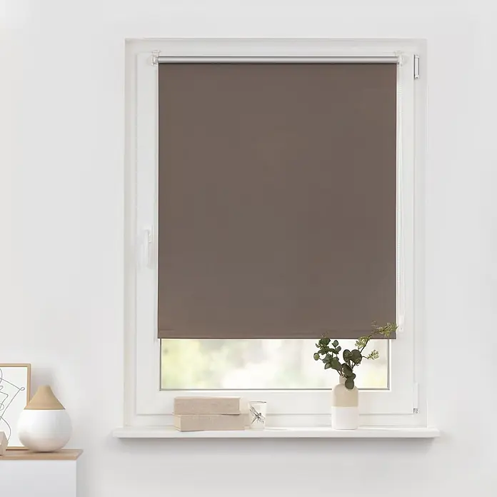 Lichtblick Thermorollo - Taupe - Braunes Stoffrollo, im weißen Fensterrahmen montiert und teilweise heruntergelassen.