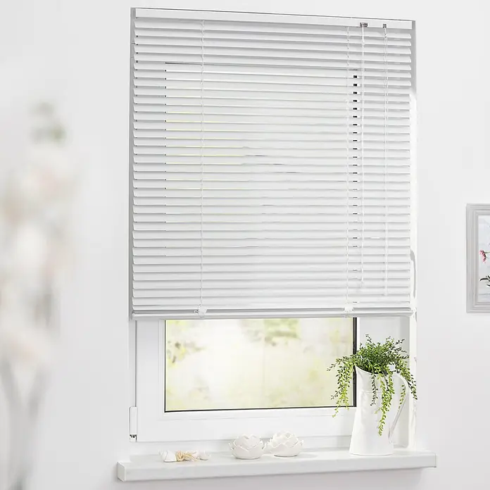 Lichtblick Jalousie - Weiß, Aluminium - Weiße Jalousien, die ein Fenster bedecken, wobei etwas Licht durch die Lamellen fällt.