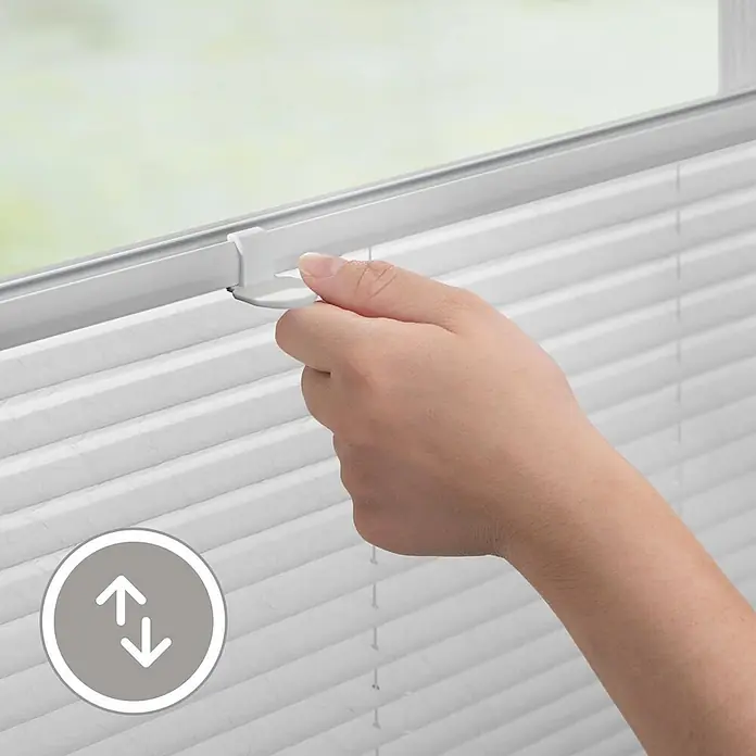 Lichtblick Plissee - Weiß - Hand verstellt eine weiße Plisseejalousie am oberen Griff.