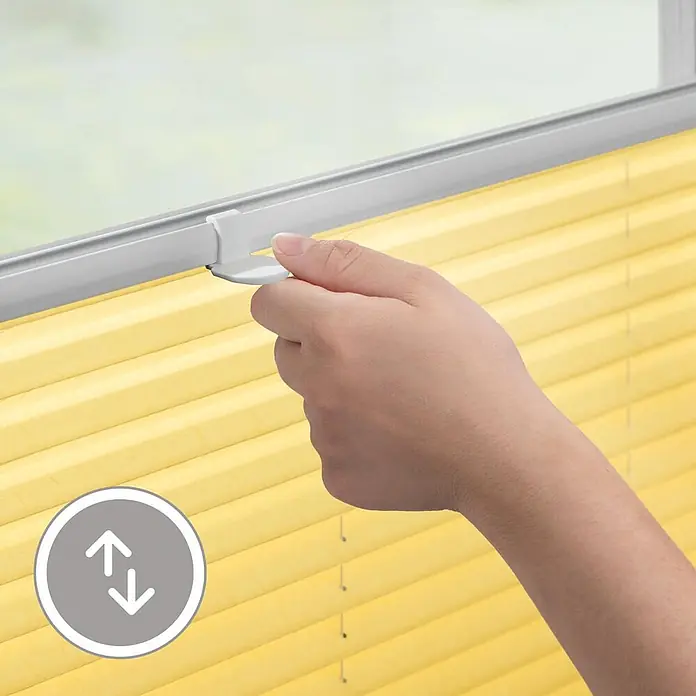 Lichtblick Plissee - Gelb - Hand verstellt ein gelbes Plissee an seinem weißen Griff am Fenster.