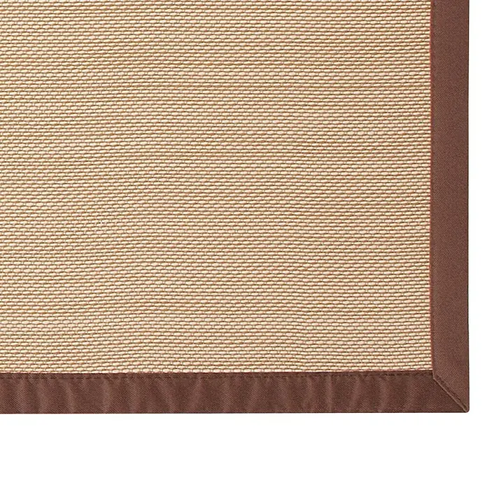 Alfombra de vinilo Living Sisal - Marrón, 90 x 60 cm - Primer plano de una alfombra de sisal con un borde marrón que muestra el tejido fino y la paleta de colores naturales de la alfombra.