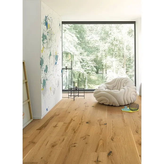 Parador Parkett - Eiche Rustic, Landhausdiele, 1.080 x 185 x 11,5 mm - Heller Holzfußboden mit natürlicher Maserung und Ästen in einem modernen Raum.