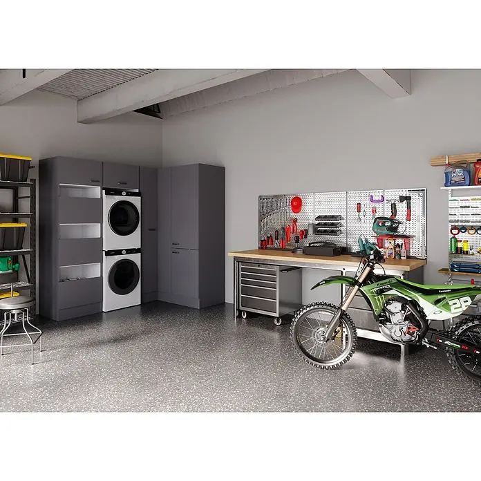 Optifit Optimulti Waschmaschinenschrank Kiel420 - L x B x H: 150 x 213,2 x 210 cm, Anthrazit - Funktionale Garage mit dunkelgrauen Lagerschränken, integrierter Werkbank, Wäschegeräten und einem grünen Motocross-Motorrad.