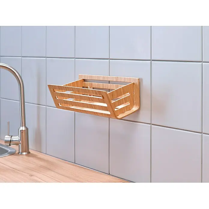 Tesa Clavo adhesivo ajustable - Blanco, Carga soportada: 3 kg, 2 ud. - Una cesta de pared de madera con diseño de listones cuelga sobre un fregadero con grifo, ofreciendo un práctico almacenamiento de cocina.