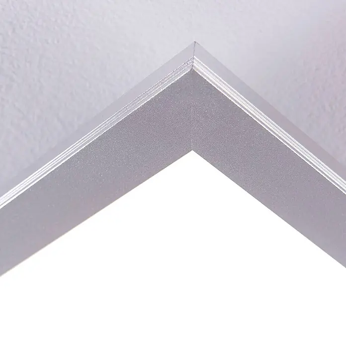 Lindby LED-Panel Livel - L x B x H: 120 x 30 x 5,2 cm, alu / grau / zink, Neutralweiß - Nahaufnahme einer silbernen Metalleckverbindung eines Rahmens, die die Gehrung und die strukturierte Oberfläche zeigt.