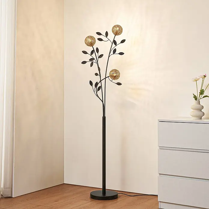 Lucande Stehleuchte Evory - schwarz, messing / gold, G9 - Hohe Stehlampe aus dunklem Metall mit Blätterdesign und drei goldenen Kugelleuchten, die warmes Licht wirft.