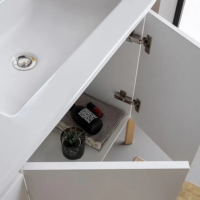 Kiamami Valentina Badmöbel-Set - Weiß - Weißer Badunterschrank mit integriertem Waschbecken und offener Schranktür, die Regal mit Toilettenartikeln und Pflanze zeigt.
