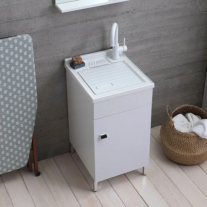 Kiamami Valentina Badmöbel-Set - Weiß - Weißer Waschbeckenschrank mit integriertem Waschbrett und Wasserhahn, in einer Waschküchenumgebung.