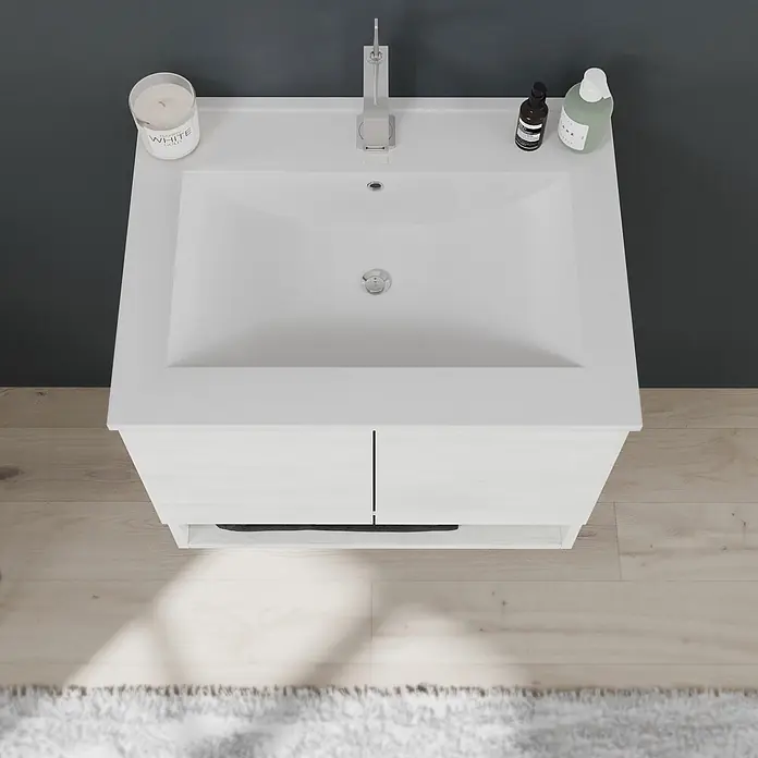 Kiamami Valentina Badmöbel-Set - Weiß - Aufsicht auf eine moderne Badezimmer-Waschtischanlage mit weißem Becken, Chromarmatur und hellem Holzunterschrank mit zwei Türen.