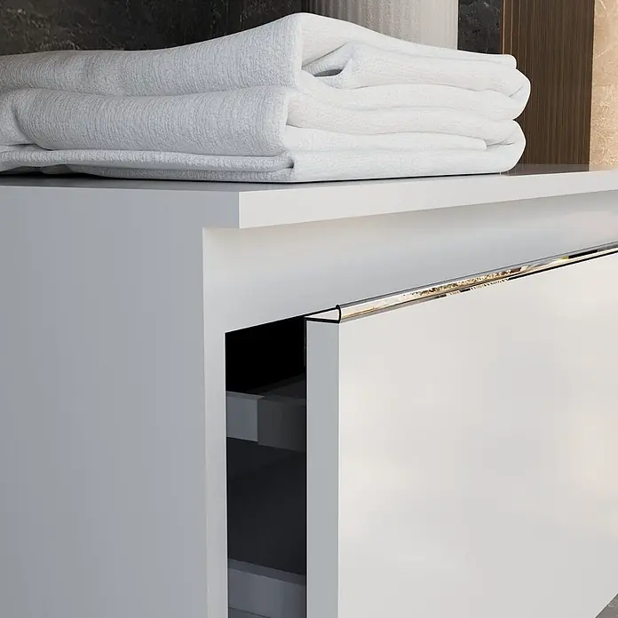 Kiamami Valentina Badmöbel-Set - Weiß - Weißer Badezimmerschrank mit beleuchtetem Griff, teilweise geöffneter Schublade, zeigt Stauraum, darauf weiße Handtücher.