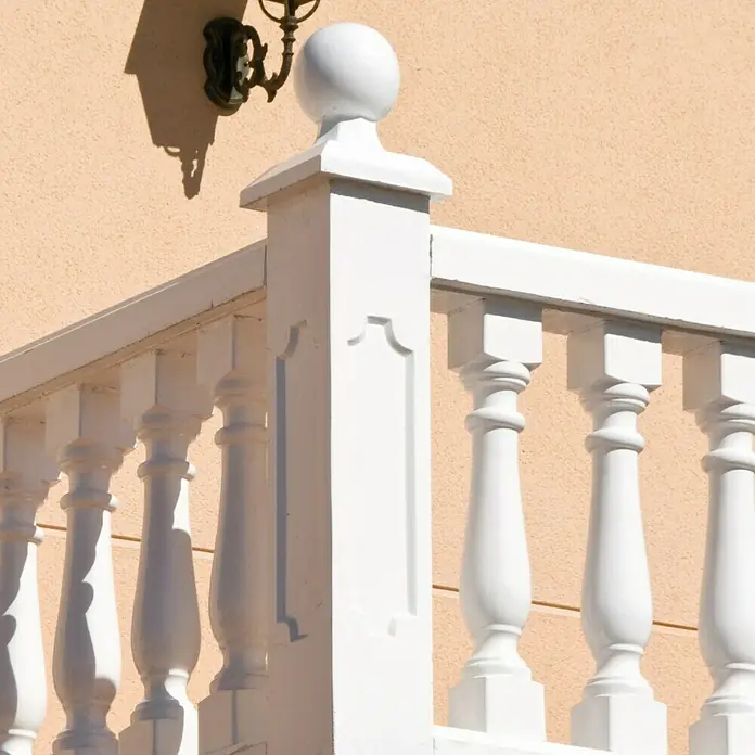 Pasamano Roma - Hormigón - Primer plano de una balaustrada blanca con columnas decorativas, destacando la elegancia arquitectónica y los elementos de diseño clásico.