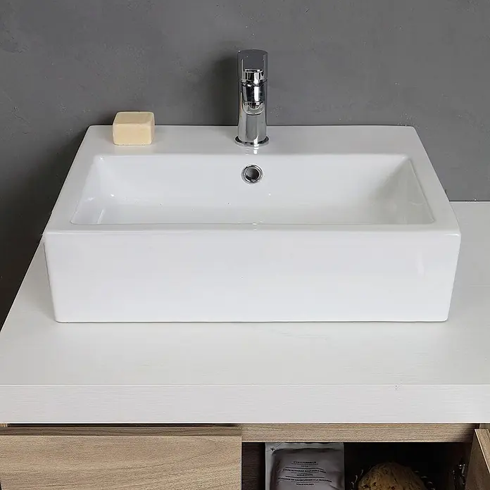 Kiamami Valentina Badmöbel-Set - Helles Holz - Weißes rechteckiges Keramikwaschbecken mit Chromarmatur und einem Stück Seife auf einer hellen Holzoptik-Waschtischplatte.