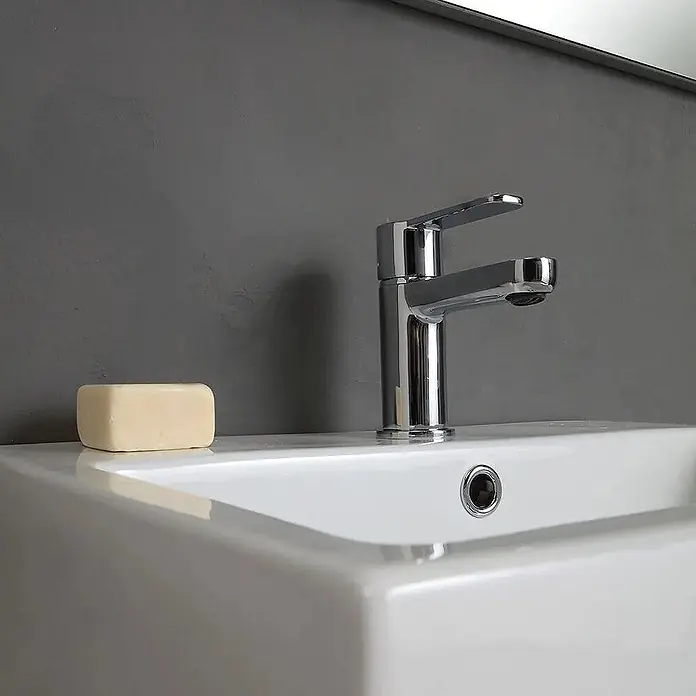 Kiamami Valentina Badmöbel-Set - Helles Holz - Weißes Keramikwaschbecken mit modernem Chromwasserhahn und einem hellen Stück Seife.