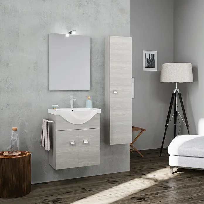 Kiamami Valentina Badmöbel-Set - Grau - Modernes Badezimmermöbel-Set mit Waschbecken, Spiegel und Hochschrank in heller Holzoptik in einem modernen Raum.