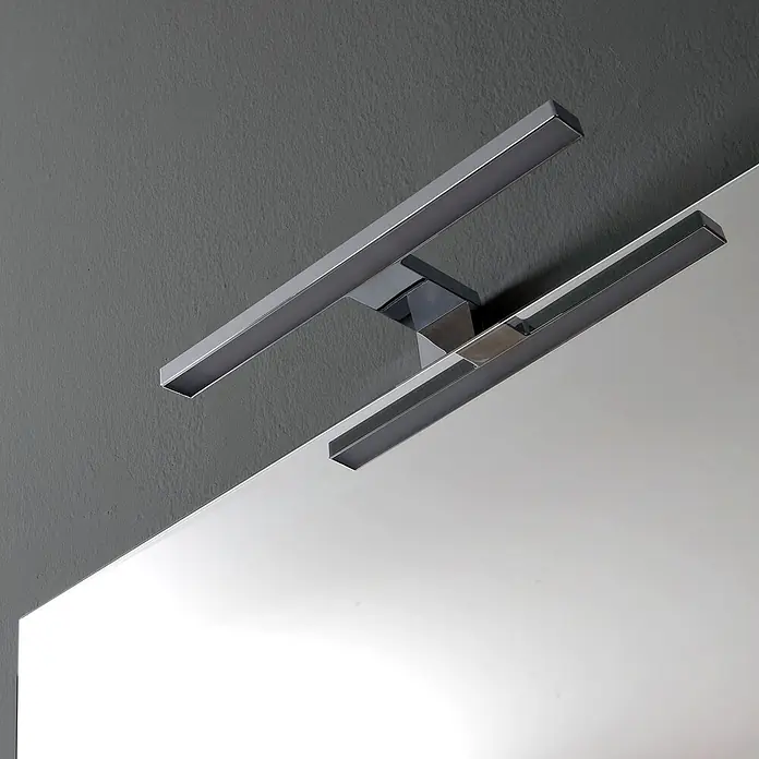 Kiamami Valentina Badmöbel-Set - Weiß - Moderne Spiegelleuchte mit zwei linearen LED-Balken in Metalloptik, über einem Spiegel montiert.