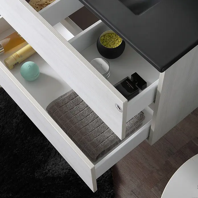 Kiamami Valentina Badmöbel-Set - Weiß - Heller Badezimmerschrank in Holzoptik mit dunkler Platte und offenen Schubladen, die Badartikel und Handtücher zeigen.