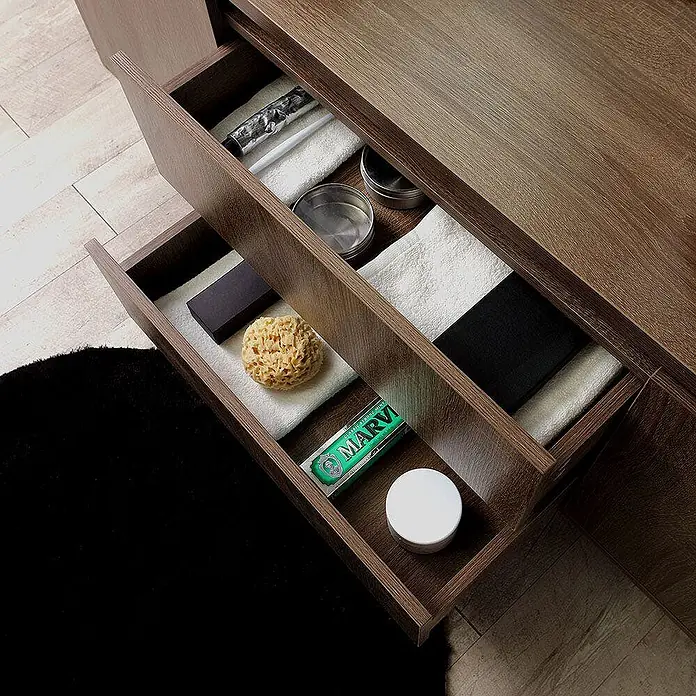 Kiamami Valentina Badmöbel-Set - Holz dunkel - Zwei offene Holzschubladen mit Toilettenartikeln wie Rasiercreme, Schwamm und Handtüchern.