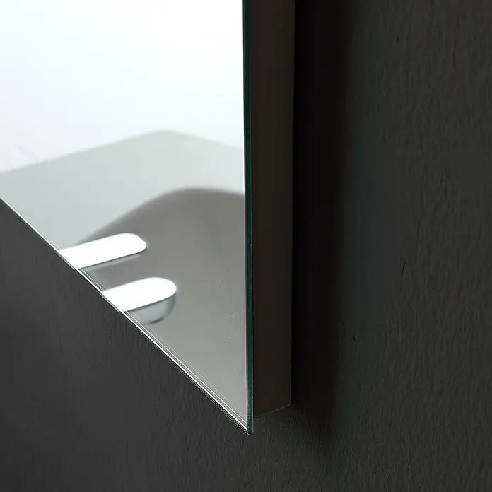 Kiamami Valentina Badmöbel-Set - Weiß - Ecke eines Spiegelschranks mit klarer Glaskante, die weiße Innenablagen an einer dunklen Wand reflektiert.