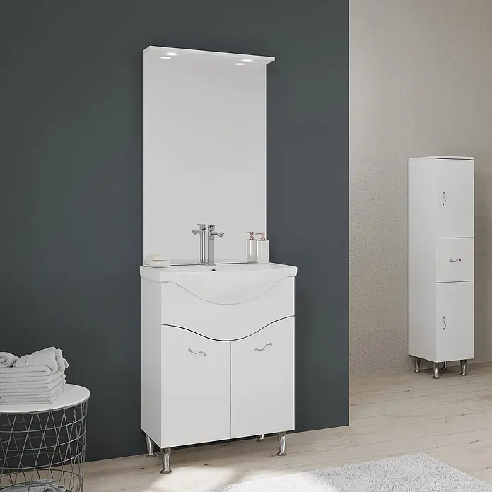 Kiamami Valentina Badmöbel-Set - Weiß - Weißer Badunterschrank mit integriertem Waschbecken, beleuchtetem Spiegel und Chromakzenten, neben einem hohen weißen Hochschrank.