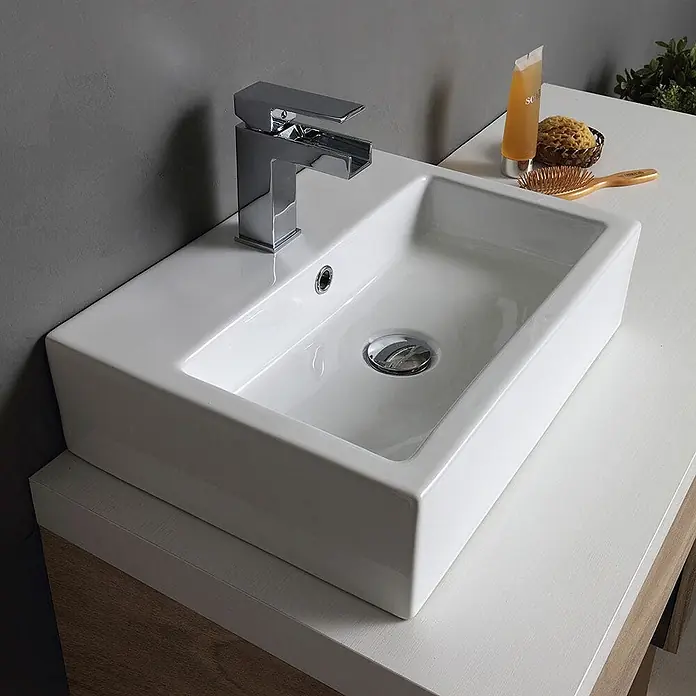 Kiamami Valentina Badmöbel-Set - Helles Holz - Weißes, rechteckiges Keramikwaschbecken mit Chromarmatur auf modernem Waschtisch im Badezimmer.