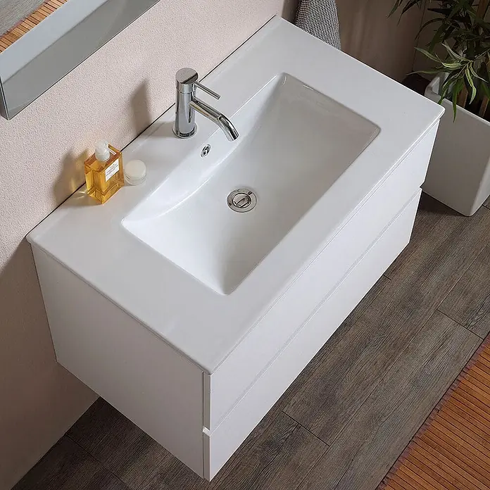 Kiamami Valentina Badmöbel-Set - Weiß - Weißer wandmontierter Badezimmer-Waschtisch mit integriertem Waschbecken und Chromarmatur, mit zwei Schubladenfronten, in einem modernen Badezimmer.