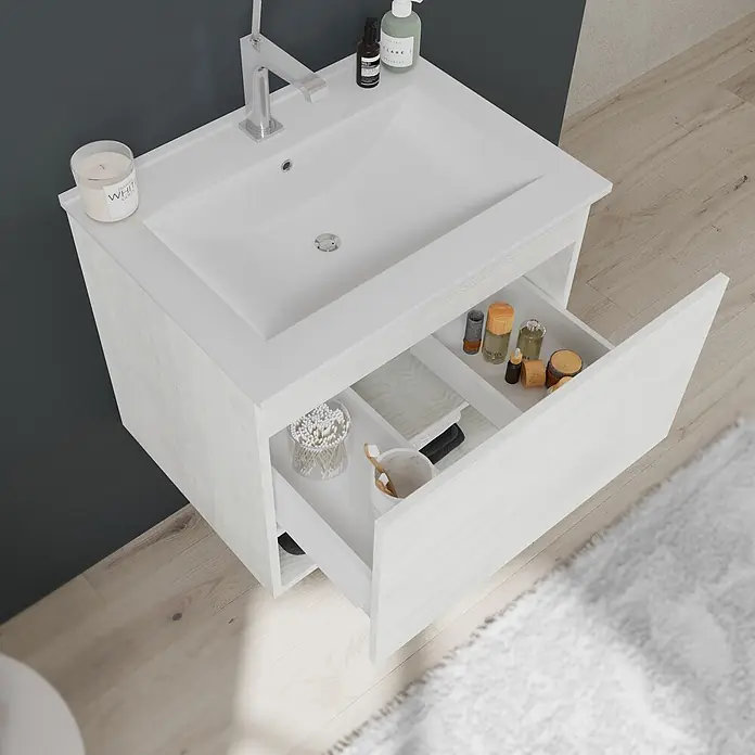 Kiamami Valentina Badmöbel-Set - Weiß - Helle Holz-Badmöbel mit weißem integriertem Waschbecken, offener Schublade mit Pflegeprodukten und Zahnbürsten in modernem Bad.