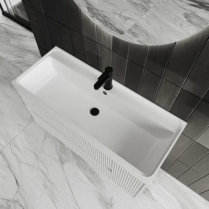 Kiamami Valentina Badmöbel-Set - Weiß - Weißes, rechteckiges Badezimmerwaschbecken mit gerippter Front, schwarzem Wasserhahn und Ablauf in einem modernen Bad.