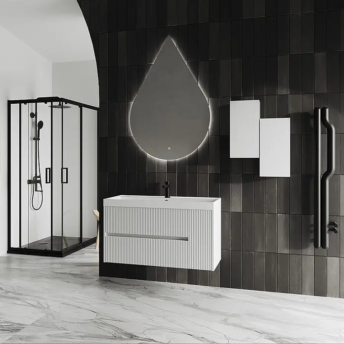 Kiamami Valentina Badmöbel-Set - Weiß - Modernes Bad mit weißem Riffelwaschtisch, schwarzem Wasserhahn, tropfenförmigem LED-Spiegel und schwarzgerahmter Dusche.