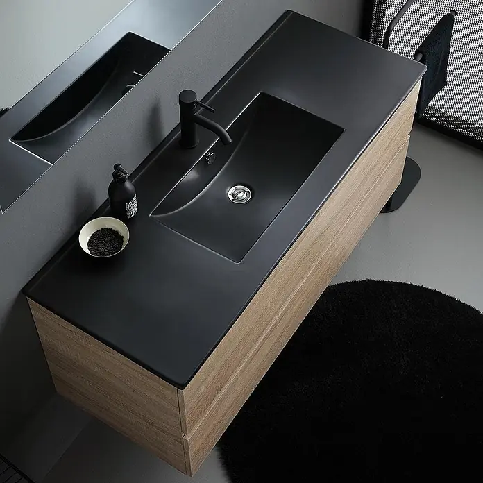 Kiamami Valentina Badmöbel-Set - Braun - Moderner Waschtisch aus hellem Holz mit schwarzem integriertem Waschbecken und passender Armatur, im Spiegel reflektiert.
