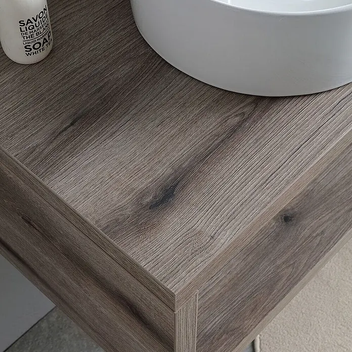 Kiamami Valentina Badmöbel-Set - Braun - Texturierte hellbraune Badkommode aus Holz mit weißem Keramikwaschbecken und Seifenspender.