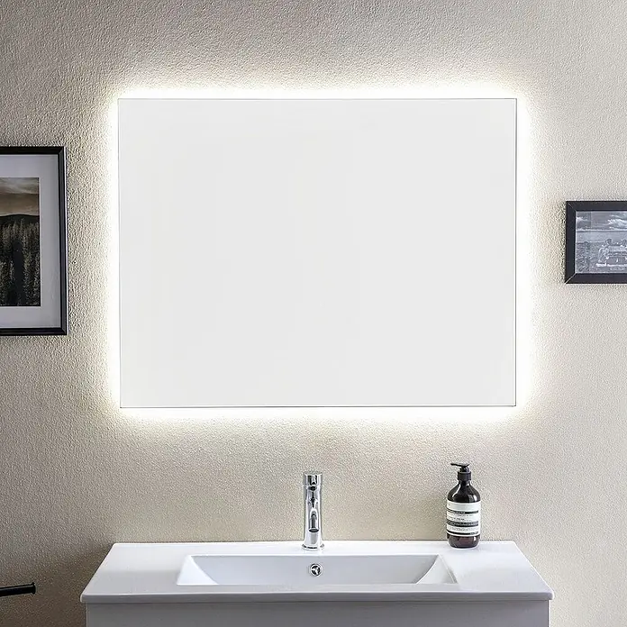 Kiamami Valentina Badmöbel-Set - Weiß - Rechteckiger Badezimmerspiegel mit integrierter LED-Hintergrundbeleuchtung, über einem weißen Waschbecken montiert.