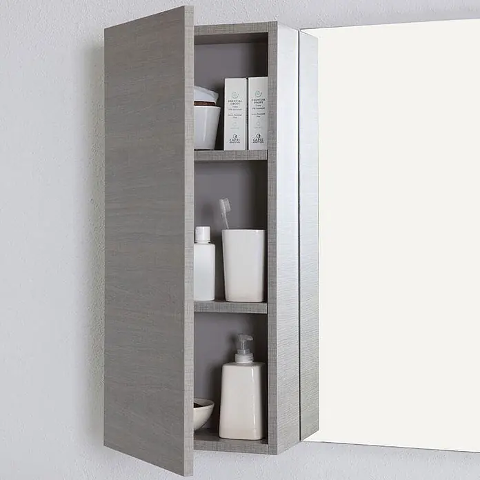 Kiamami Valentina Badmöbel-Set - Grau - Grauer wandmontierter Badschrank in Holzoptik mit halb offener Tür, der Regale mit Toilettenartikeln und eine Spiegelseite zeigt.