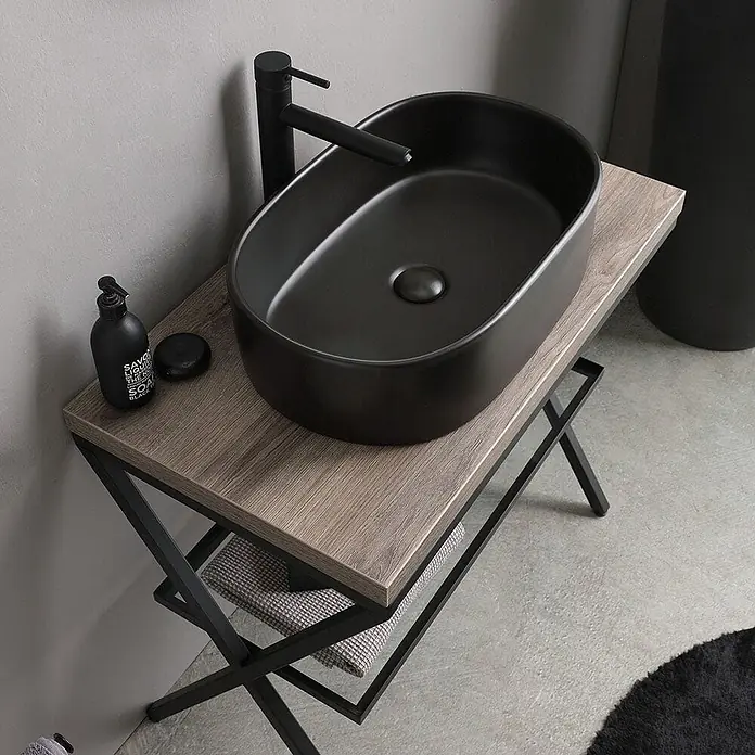 Kiamami Valentina Badmöbel-Set - Schwarz, Braun - Schwarzes ovales Keramik-Aufsatzwaschbecken mit passender Armatur auf einem Holzwaschtisch mit schwarzem Metallgestell.