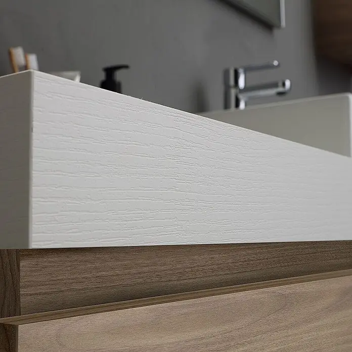 Kiamami Valentina Badmöbel-Set - Holz mittel - Weiße, strukturierte Waschtischplatte über Holzschubladen in einem modernen Badezimmer.