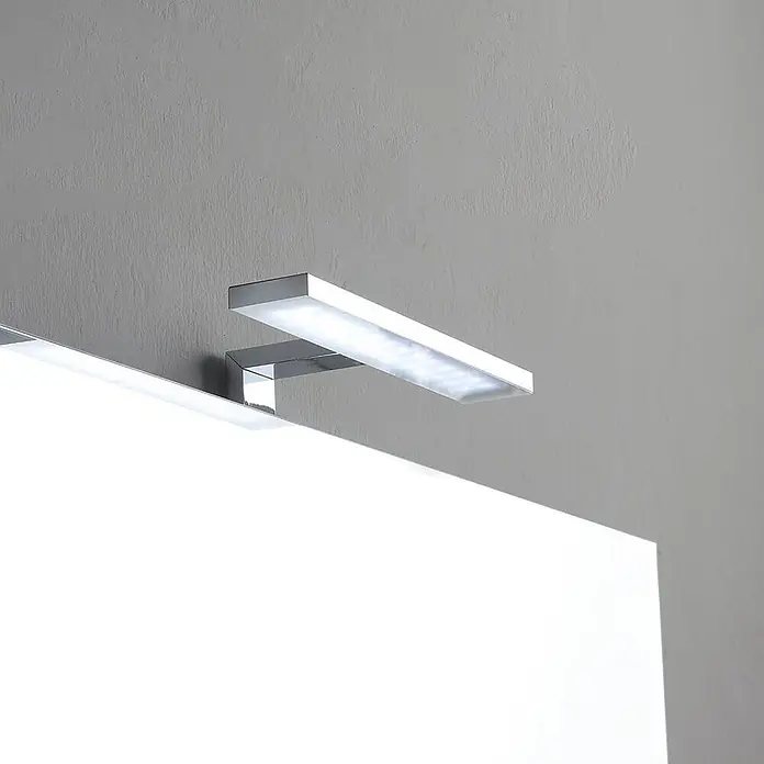 Kiamami Valentina Badmöbel-Set - Schwarz - Verchromte LED-Spiegelleuchte mit rechteckigem Design, die helles weißes Licht über einem Spiegel abgibt.