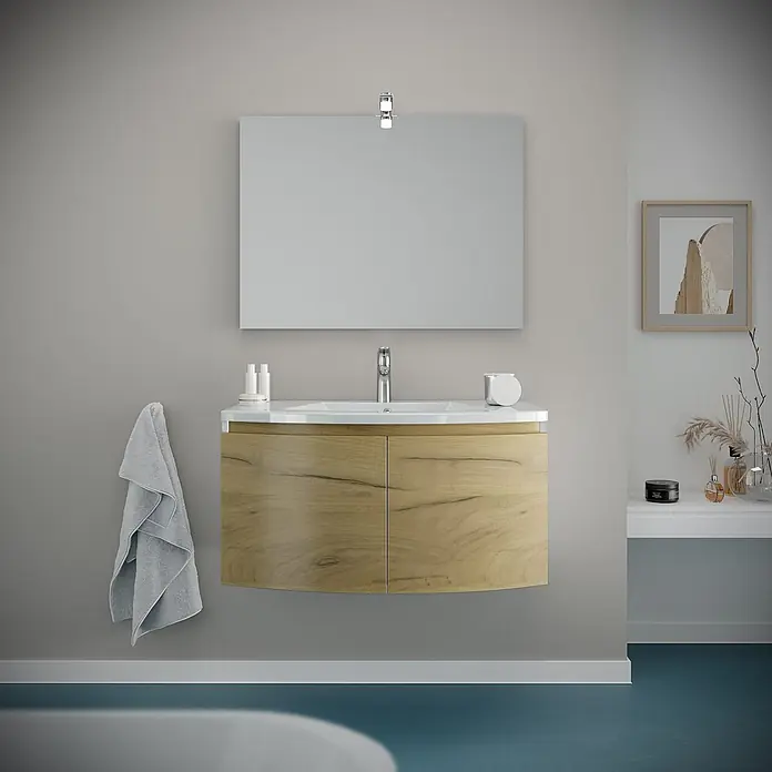 Kiamami Valentina Badmöbel-Set - Holz mittel - Heller Badschrank aus Holz mit weißem Waschbecken und rechteckigem Spiegel darüber in einem modernen Badezimmer.