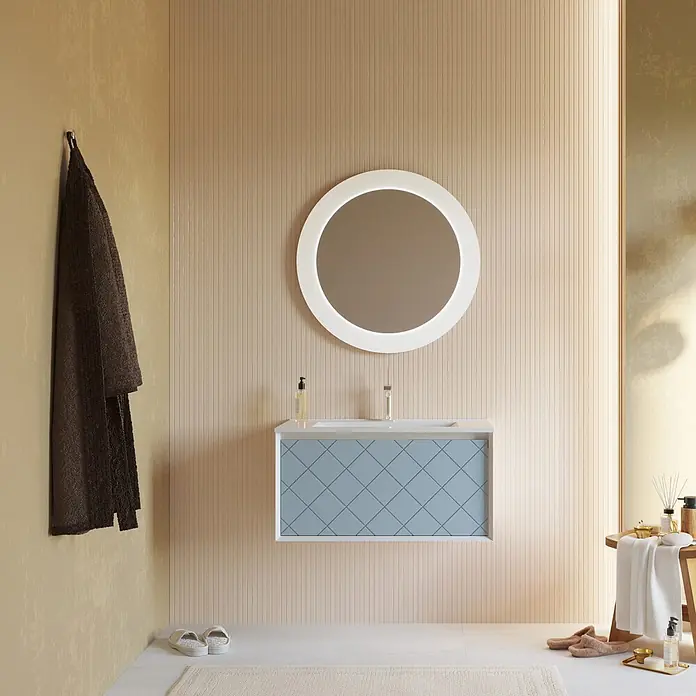 Kiamami Valentina Badmöbel-Set - Hellblau - Moderner Badwaschtisch mit hellblauem geometrisch gemustertem Schrank, weißer Arbeitsplatte, Waschbecken und rundem beleuchtetem Spiegel darüber.