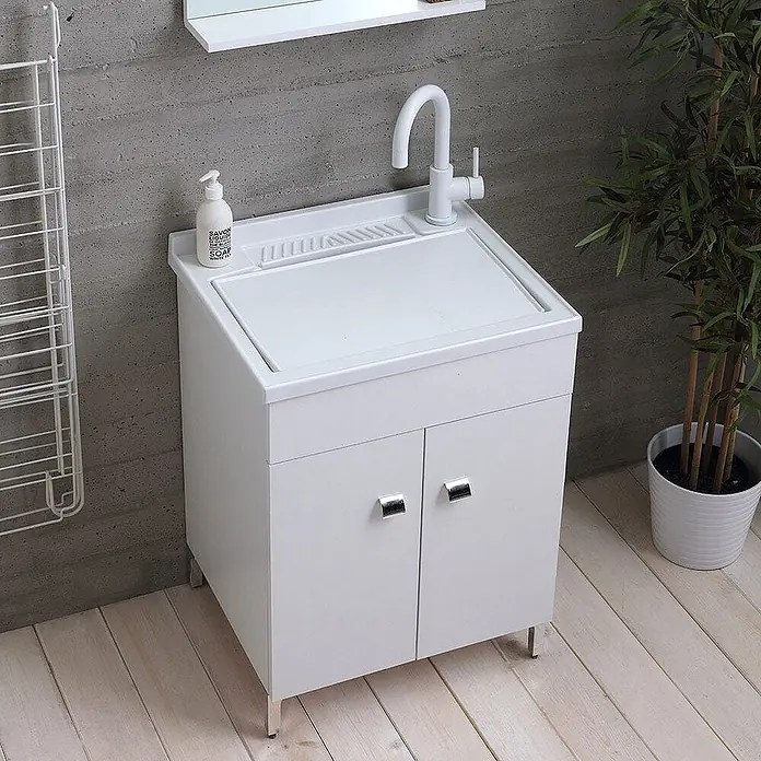 Kiamami Valentina Badmöbel-Set - Weiß - Weißer Waschbeckenschrank mit integriertem Waschbrett, weißem Wasserhahn und zweitürigem Stauraum auf Metallfüßen.
