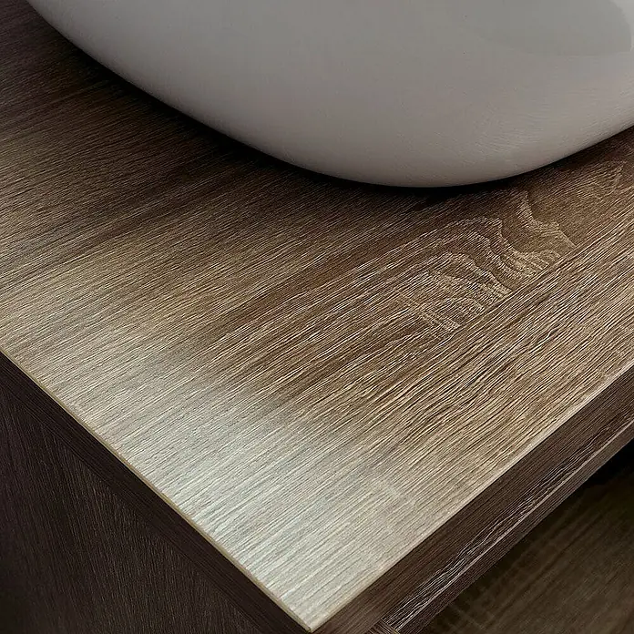 Kiamami Valentina Badmöbel-Set - Holz dunkel - Weißes ovales Waschbecken auf einer hellbraunen Holzoptik-Waschtischplatte.