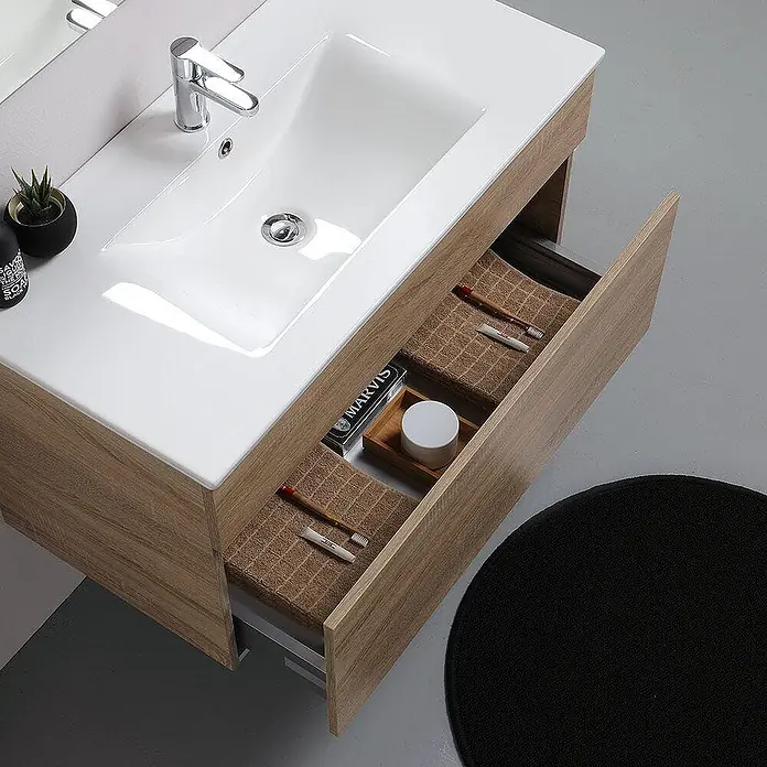 Kiamami Valentina Badmöbel-Set - Helles Holz - Heller Waschtisch in Holzoptik mit weißem Waschbecken und teils geöffneter Schublade für Badutensilien.
