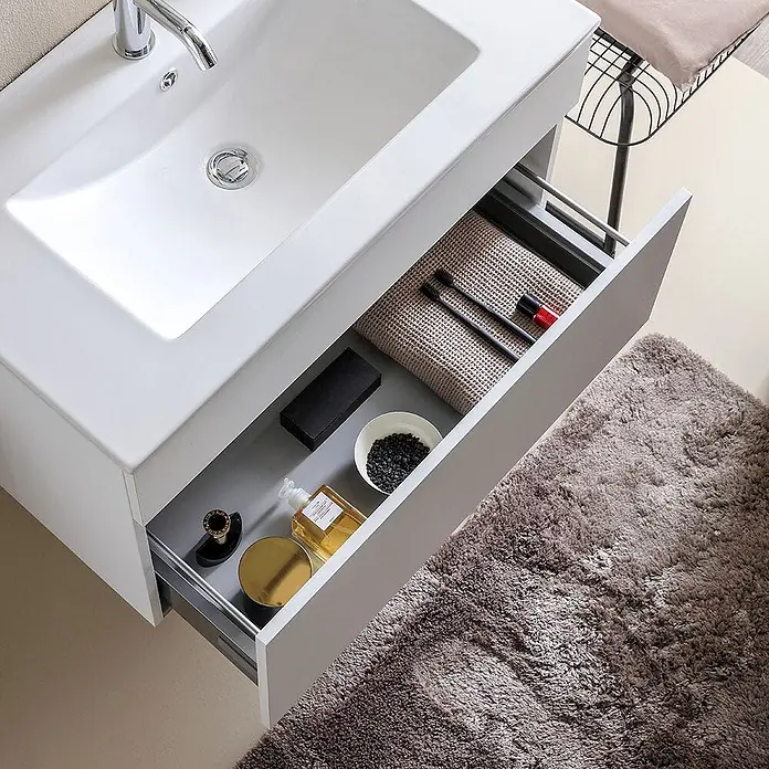 Kiamami Valentina Badmöbel-Set - Grau - Weißer Badezimmerschrank mit integriertem Waschbecken und offener Schublade für Pflegeprodukte.