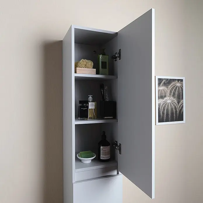 Kiamami Valentina Badmöbel-Set - Grau - Hellgrauer Wand-Badezimmerschrank mit offener Tür und Regalen voller Toilettenartikel.