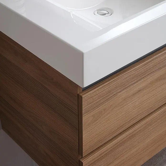 Kiamami Valentina Badmöbel-Set - Braun - Weißes Waschbecken auf braunem Holzwaschtisch mit zwei Schubladen.
