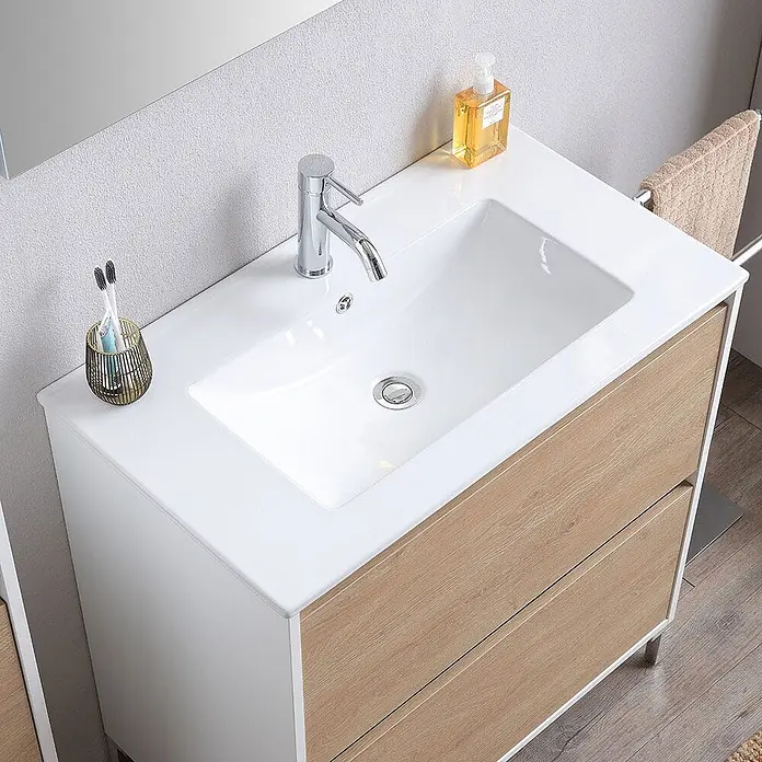 Kiamami Valentina Badmöbel-Set - Helles Holz - Weißer Badschrank mit integriertem Keramikwaschbecken, Chromarmatur und hellen Holzschubladen.