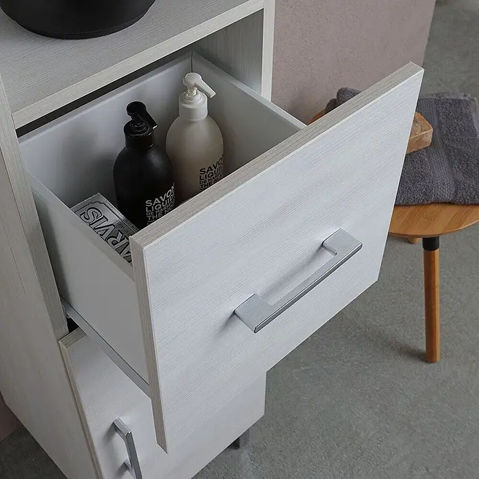 Kiamami Valentina Badmöbel-Set - Helles Holz - Heller Badschrank in Holzoptik mit geöffneter Schublade, die Spenderflaschen und praktische Badaufbewahrung zeigt.
