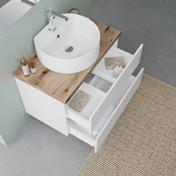 Kiamami Valentina Badmöbel-Set - Weiß - Weißer Badezimmerschrank mit Holzplatte, weißem Aufsatzwaschbecken und zwei offenen Schubladen.